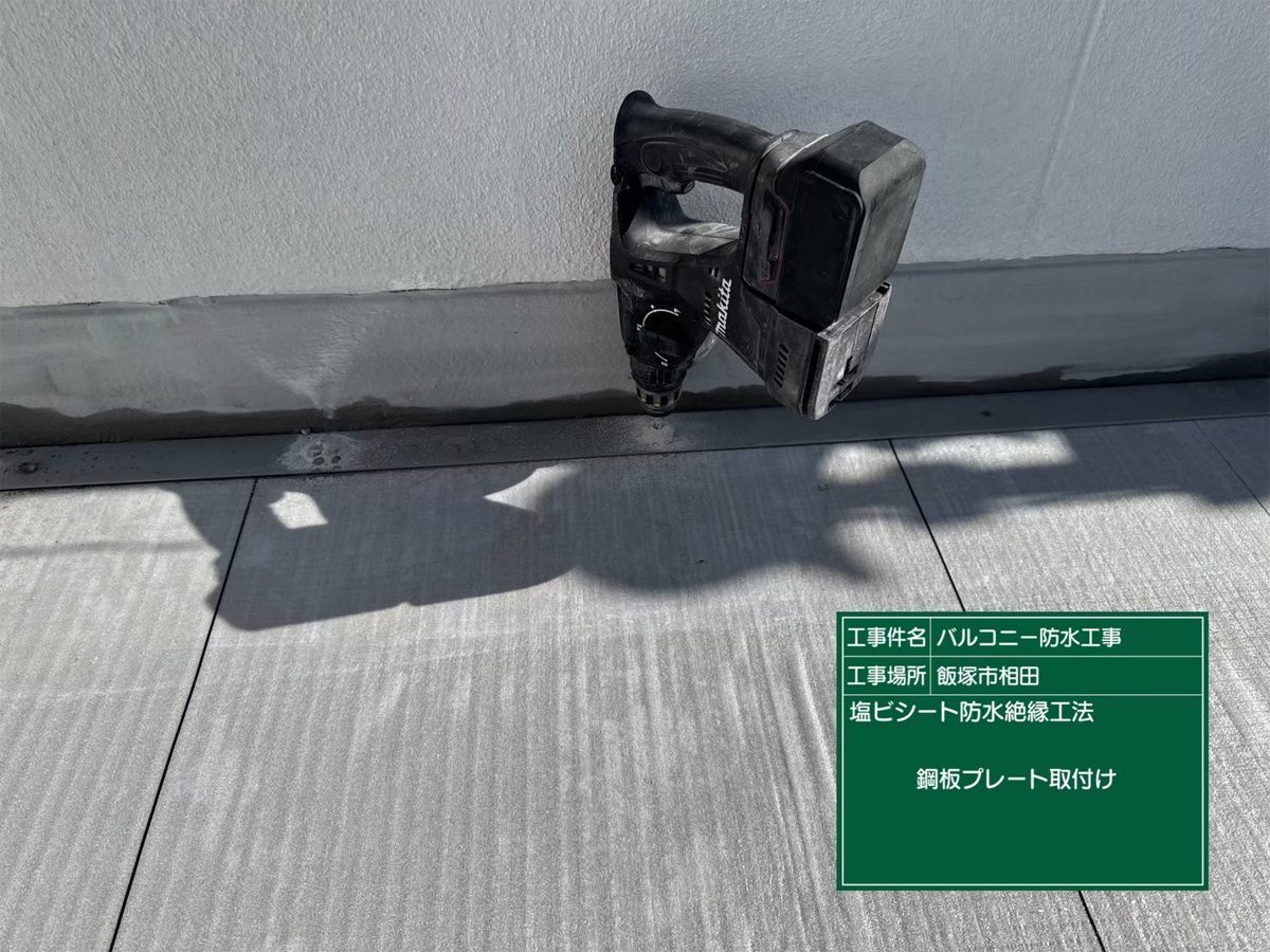 壁際に鋼板プレートを取り付けている様子