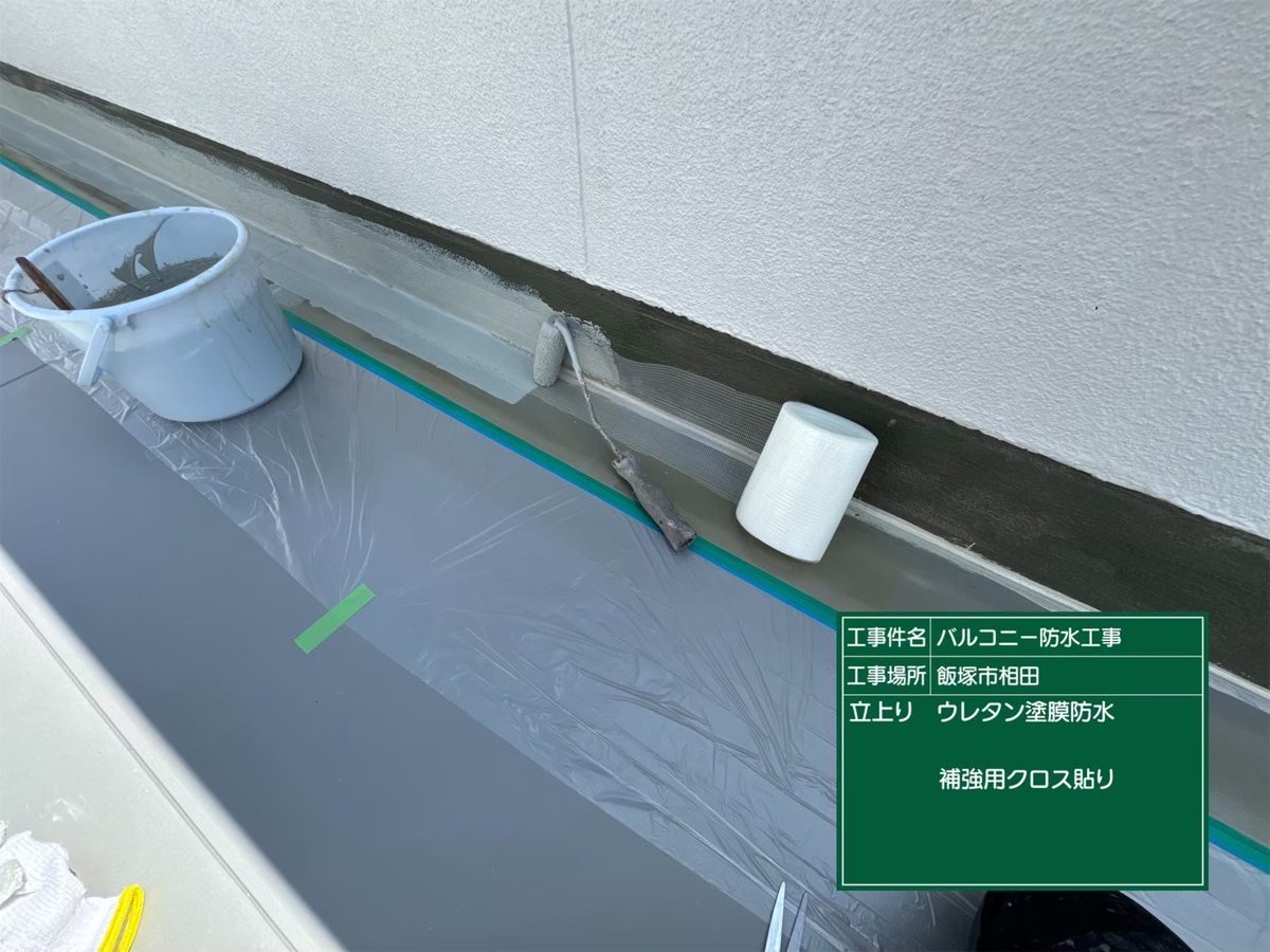 立上りに補強用クロスを貼っている様子
