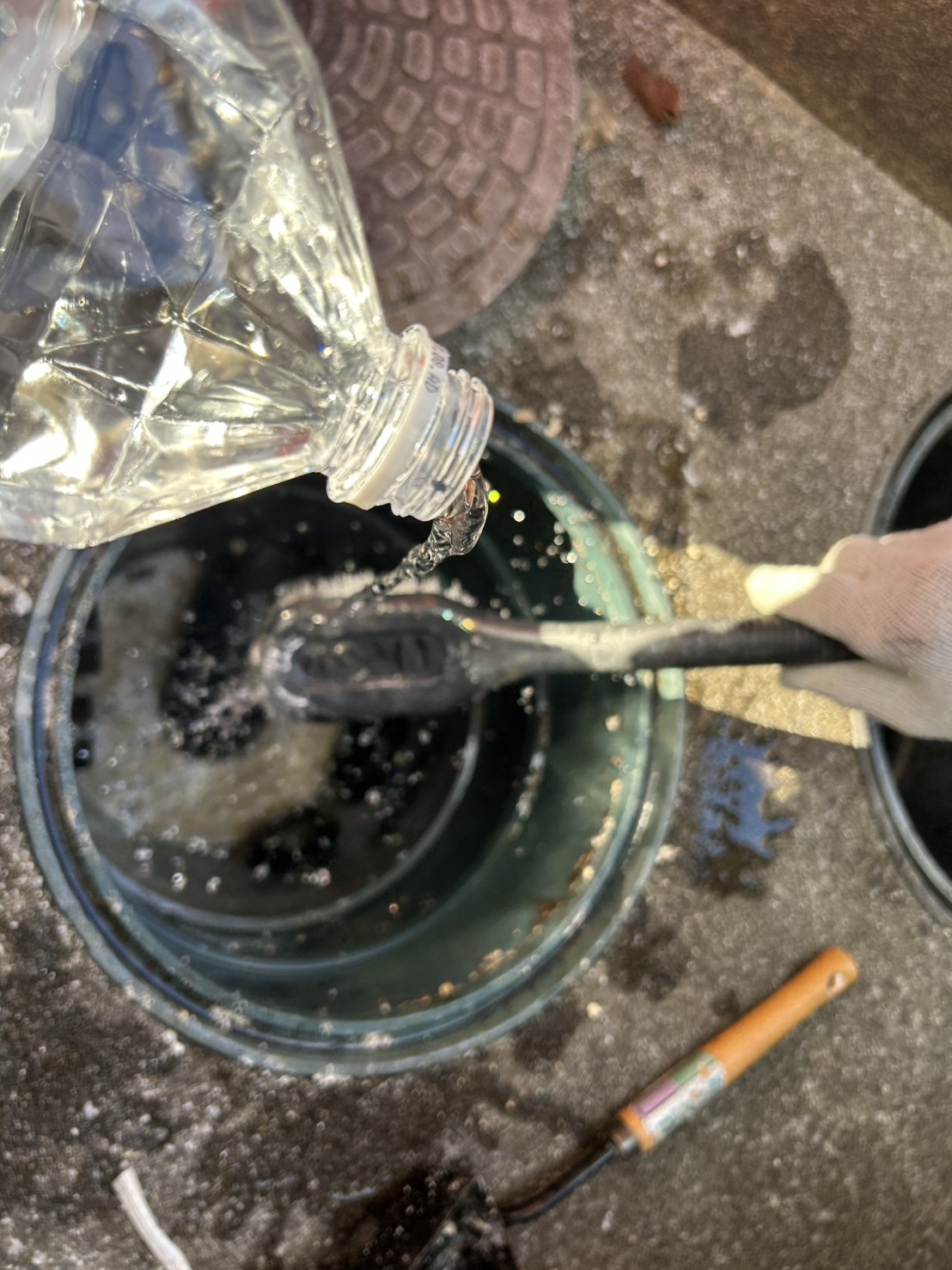 ブラシと水で排水桝を洗浄